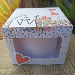 Embalagem de papel tridimensional com visor superior transparente vazado, abas de fechamento laterais e espaço sob medida para acomodar um mini bolo bentô cake com segurança, exibindo marcas de dobra e vinco em arquivo digital de corte.