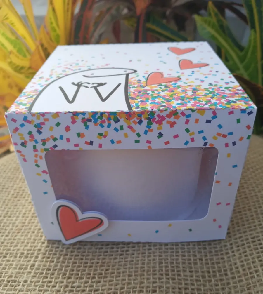 Embalagem de papel tridimensional com visor superior transparente vazado, abas de fechamento laterais e espaço sob medida para acomodar um mini bolo bentô cake com segurança, exibindo marcas de dobra e vinco em arquivo digital de corte.