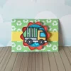 Suporte de papel para dois chocolates com aplique tridimensional de um caminhão de coleta de lixo na cor laranja e cinza com contornos limpos em arquivo digital de corte.