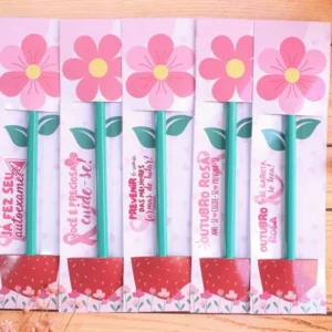 Cartão de papel retangular com fundo rosa claro texturizado e estampas de mini corações brancos, apresentando ilustrações de laços da campanha e duas aberturas horizontais exatas para encaixe de um lápis em arquivo digital.