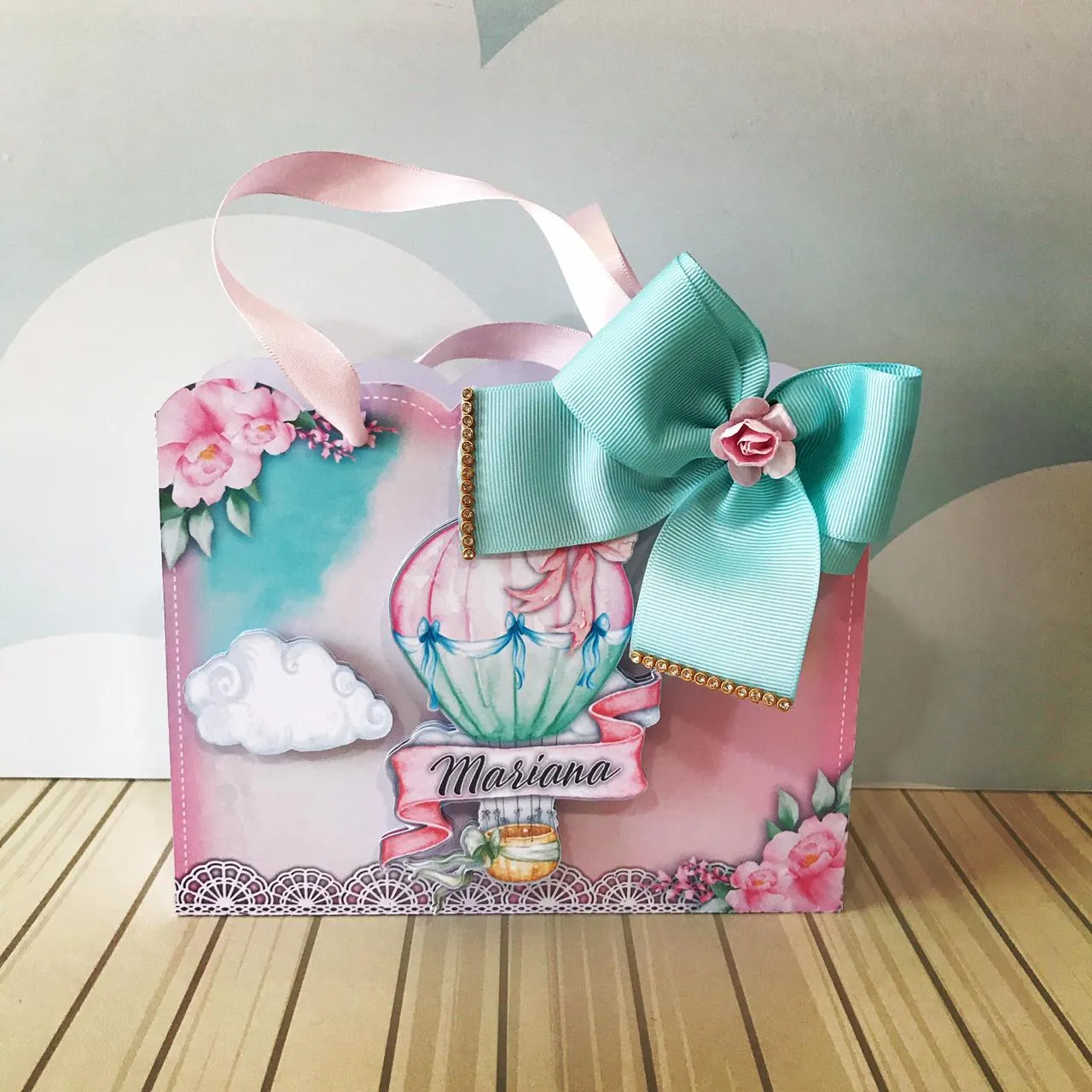 Embalagem sextavada com estampa floral delicada de rosas, trazendo no topo um balão de ar quente com detalhes de mini pérolas ilustradas e laço de fita rosa em camadas tridimensionais em arquivo digital de corte.