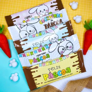 Embalagem envolvente para barra de chocolate planificada com estampa de coelhinho da páscoa sorridente segurando um pincel colorido, rodeado por ovinhos decorados e ramos de flores em tons pastéis sobre fundo imitando textura de chocolate, em arquivo digital.