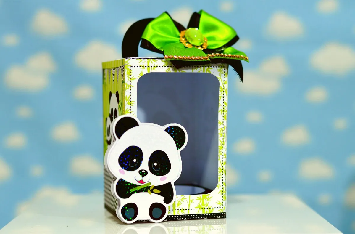 Topper de bolo com filhote de panda em camadas tridimensionais com detalhes em tons de azul e verde para decoração de festas.