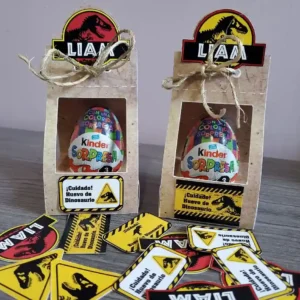 Arquivo de corte digital de suporte decorativo para Kinder Ovo no tema Jurassic Park em formato Studio para Silhouette, mostrando o contorno do portão do parque, dinossauros em camadas e o nicho central vazado para encaixe do chocolate.