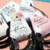 Tag de papel em formato de gravata com fundo rosa pastel e estampa de mini corações brancos, trazendo na parte frontal a frase "Um mimo para agradecer a sua preferência" escrita em letras cursivas e elegantes em arquivo digital.