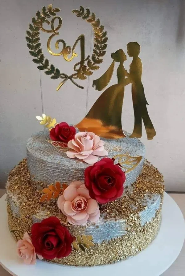 Topper de bolo elegante com a silhueta de um casal de noivos, onde o noivo segura a noiva pela cintura sob um imponente portal de flores com arabescos, dispostos em camadas tridimensionais em arquivo digital de corte.