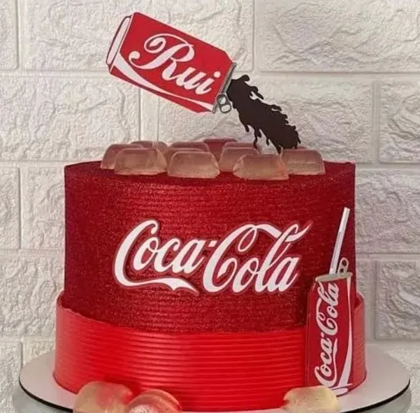 Topper de bolo com uma lata vermelha clássica de refrigerante inclinada derramando a bebida com gelo e bolhas realistas em um copo, com a logomarca cursiva branca em camadas tridimensionais em arquivo digital de corte.