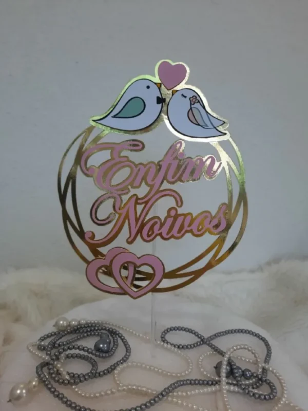 Topper de bolo romântico com a frase enfim noivos escrita em letras cursivas e sofisticadas, decorada com a silhueta de um casal trocando alianças e pequenos corações delicados, dispostos em camadas tridimensionais em arquivo digital de corte.