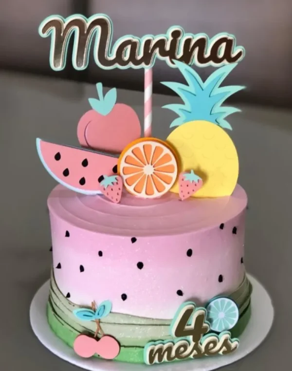 Topper de bolo delicado com tema quitandinha em tons pastéis, exibindo ilustrações fofas de melancia, abacaxi e morango em cores suaves com detalhes dourados, dispostos em camadas tridimensionais em arquivo digital de corte.