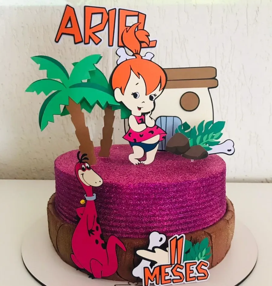Topper de bolo com a personagem Pedrita Baby usando seu vestido de estampa de oncinha e um osso no cabelo preso, cercada por elementos da Idade da Pedra em camadas tridimensionais para decoração de festa em arquivo digital de corte.
