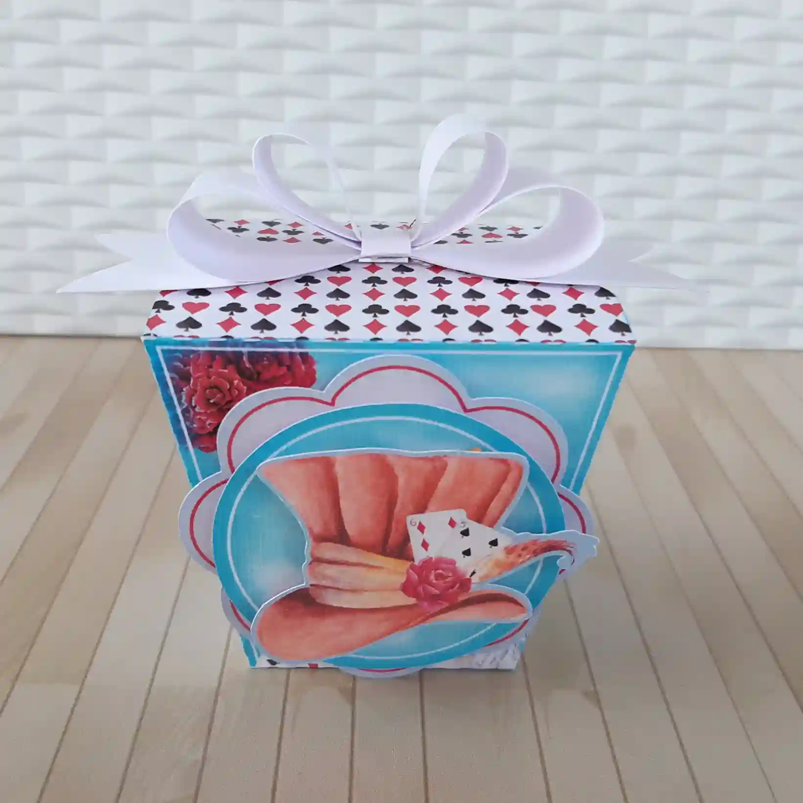 Molde digital de caixa de papel simulando um livro antigo fechado, com lombada decorada, ilustrações do Gato de Cheshire sorrindo na capa e fecho de encaixe.