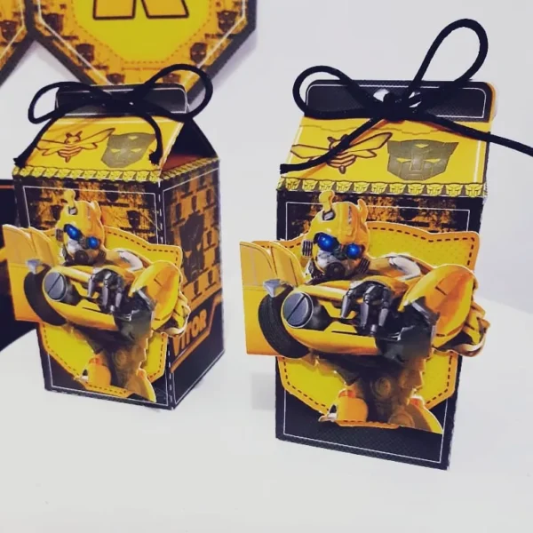 Molde digital de caixinha pirâmide amarela e preta com estampa de engrenagens, exibindo aplique tridimensional do robô Bumblebee em pose de batalha no topo.