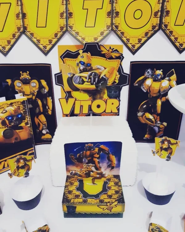 Molde de caixa milk amarela com listras pretas de corrida, exibindo o escudo dos Autobots e o carro esportivo Bumblebee em relevo tridimensional na frente.