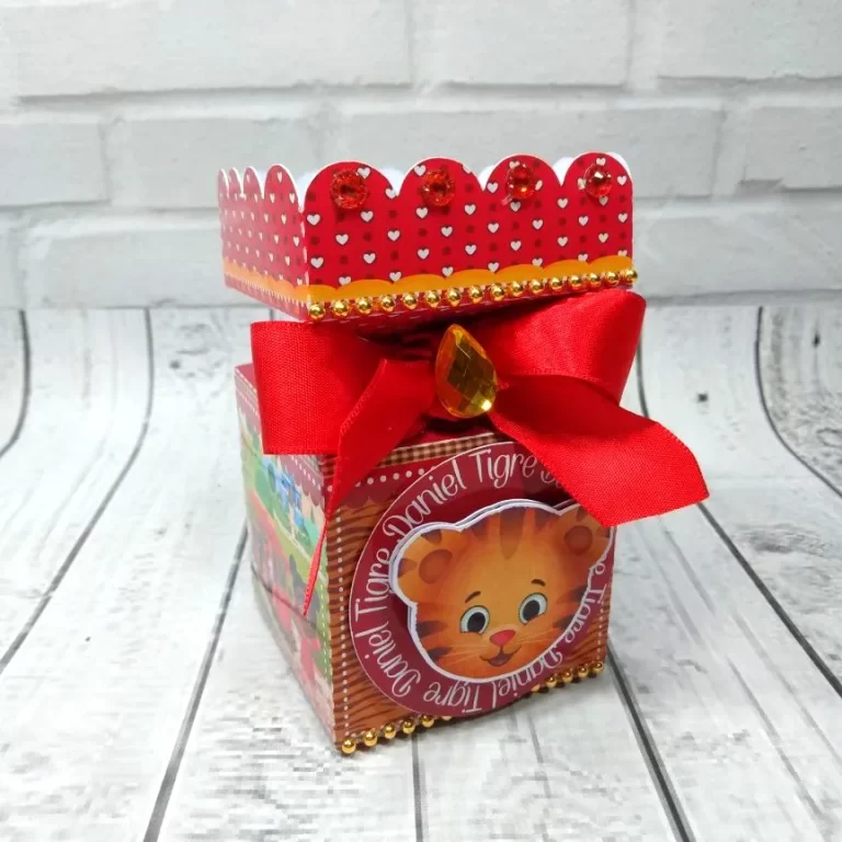 Embalagem de papel em formato de caixa milk decorada com o rosto do Daniel Tigre e listras laranjas, contendo linhas de vinco pontilhadas e abas de colagem em arquivo digital de corte.