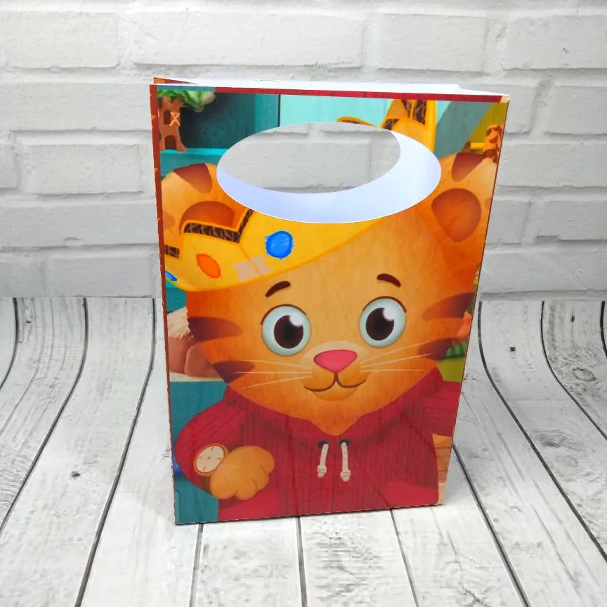Alternativo: Sacolinha de papel com alça vazada estampada com o tema Daniel Tigre e seus amigos do bairro da amizade, com linhas pontilhadas de vinco em arquivo digital de corte.
