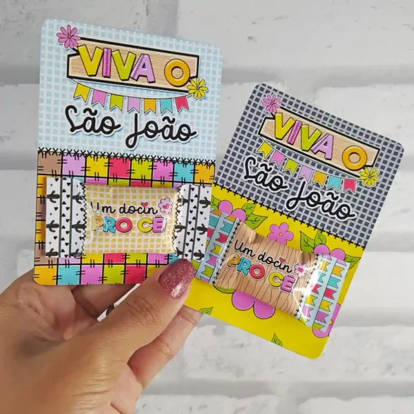 Molde em imagem de caixa pirâmide alongada simulando um balão junino tradicional, decorada com texturas de retalhos de chita e franjas de papel coloridas nas pontas.