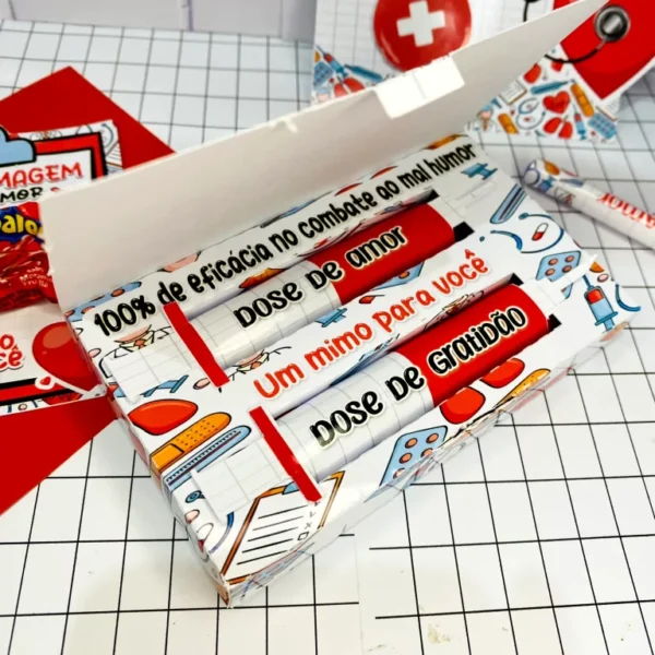 Sacolinha de papel com alça vazada estampada com padrão de curativos, estetoscópios e remédios em fundo azul claro, apresentando linhas pontilhadas de vinco em arquivo digital de corte.