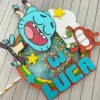 Molde digital de caixinha pirâmide imitando uma televisão retrô cinza, com tela exibindo os personagens Gumball e Darwin acenando de dentro em relevo 3D.