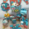 Molde de caixa milk azul-claro decorada com nuvens brancas, exibindo o rosto do gato Gumball de um lado e do peixe Darwin do outro, em apliques sobrepostos de papel.