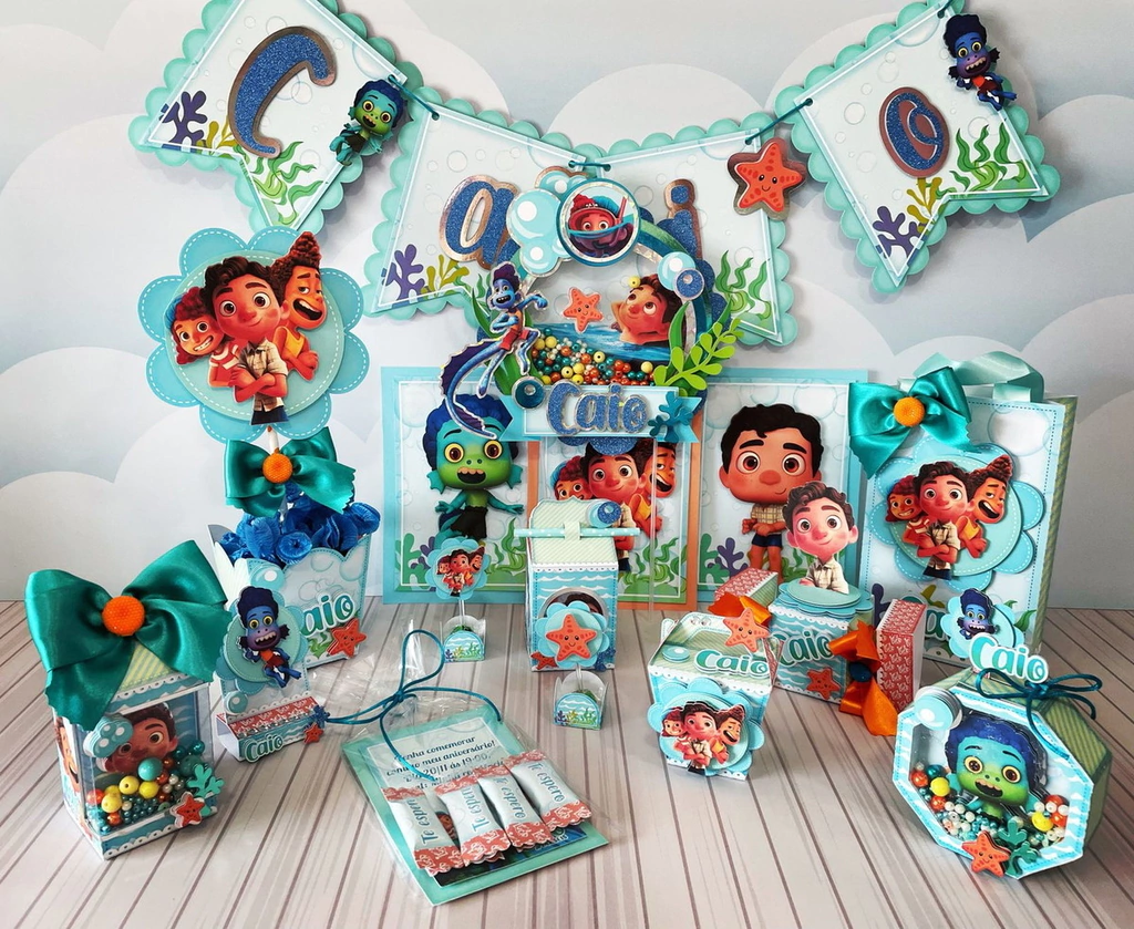 Molde de caixa milk decorada com padronagem de escamas brilhantes na base, ondas recortadas em camadas azuis e aplique do Luca em sua forma de criatura marinha.