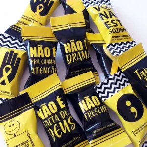 Gabarito digital de rótulos e embalagens para balas personalizadas com frases motivacionais, corações e o laço amarelo símbolo da campanha, exibindo as linhas estruturadas de contorno para recorte.