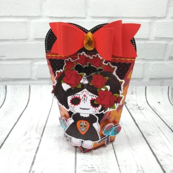 Molde de corte para centro de mesa tridimensional com silhueta de caveira decorada e detalhes vazados para apliques de papel.