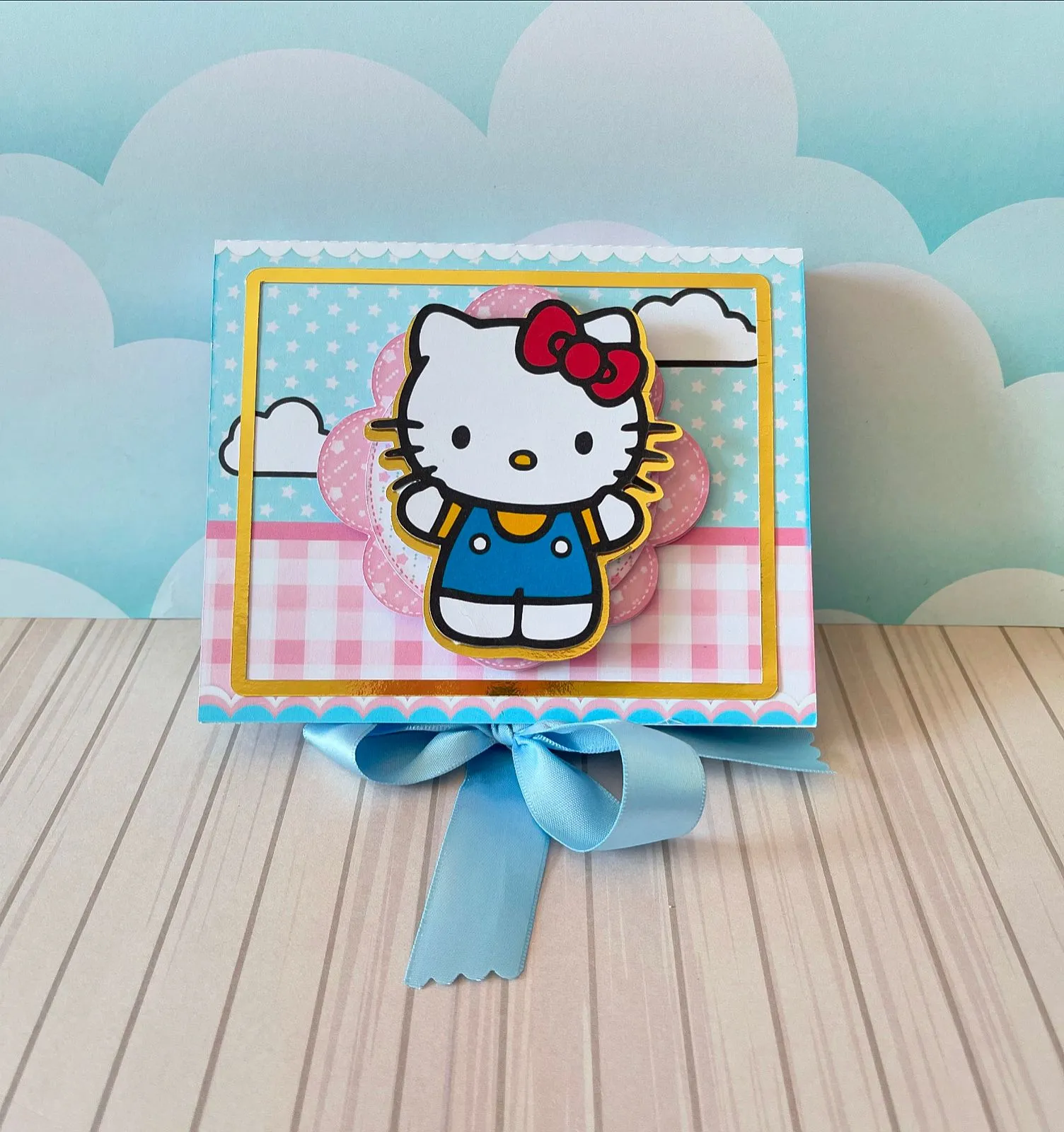 Cachepô decorativo com o rosto da Hello Kitty e laço tridimensional para suporte de balões em decoração de festa infantil.