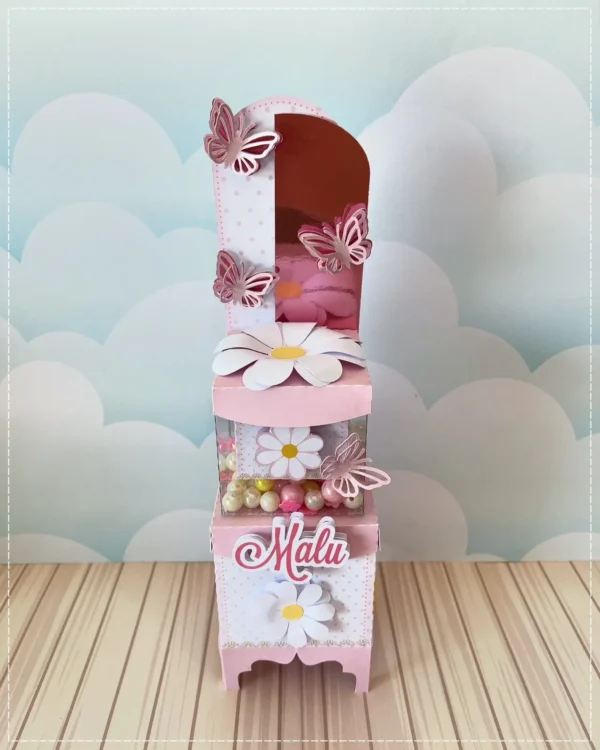 Centro de mesa com cachepô delicado em tons pastéis de rosa candy e verde água, com uma margarida sorridente em versão infantil no centro, nuvens fofas brancas e mini estrelas flutuando em camadas tridimensionais em arquivo digital de corte.