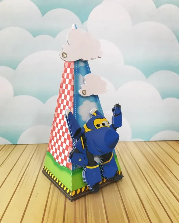 Arquivo de corte de caixinha de papel no formato de mala de viagem antiga azul-escura, com carimbos de passaporte falsos e o avião acrobático Jerome saltando na frente.