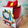Centro de mesa estruturado com a locomotiva azul Thomas para decoração de festas em formato Studio e PDF.