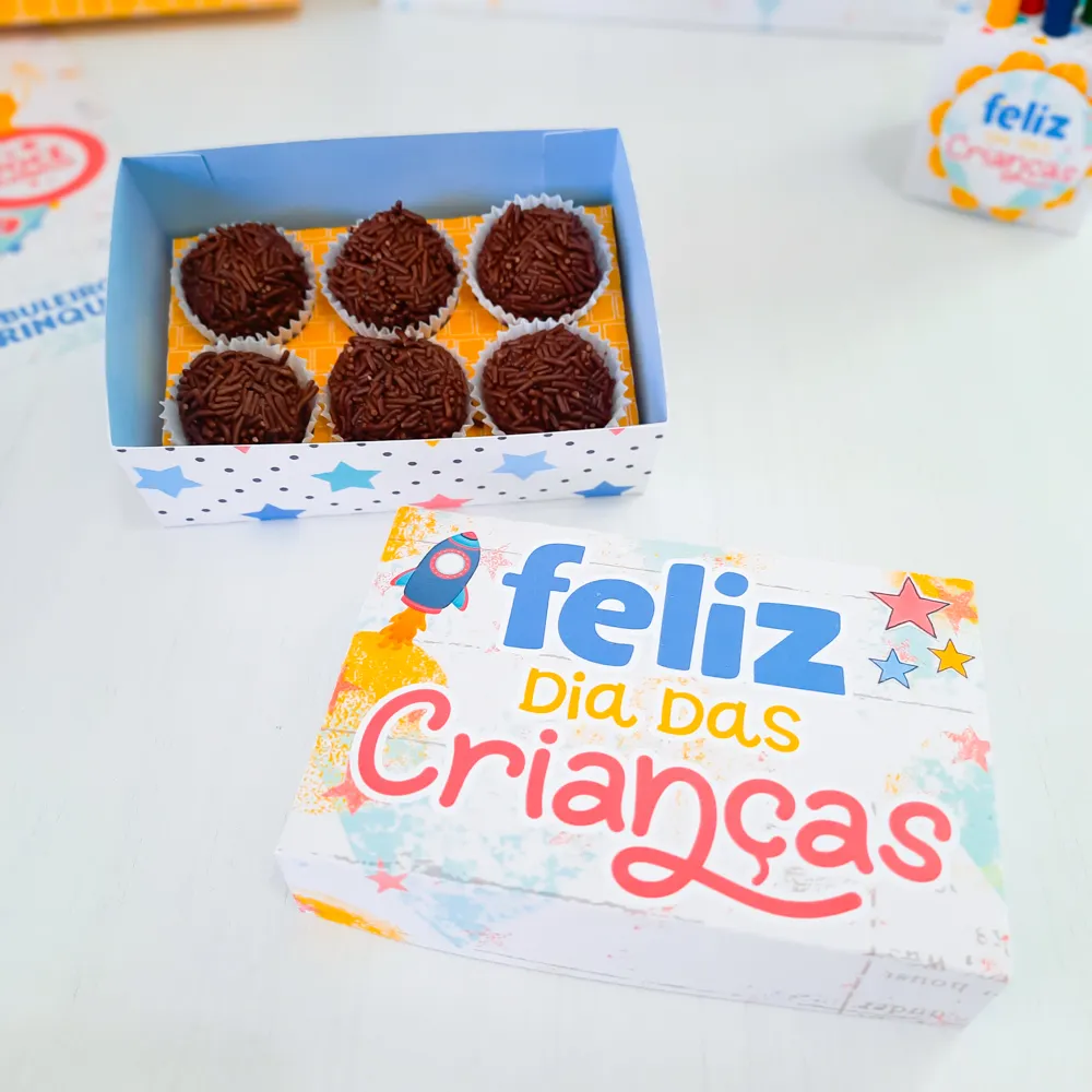 Arquivos digitais abertos em programa de recorte mostrando moldes de caixas de doces, tags comemorativas e toppers de bolo de Dia das Crianças prontos para impressão.