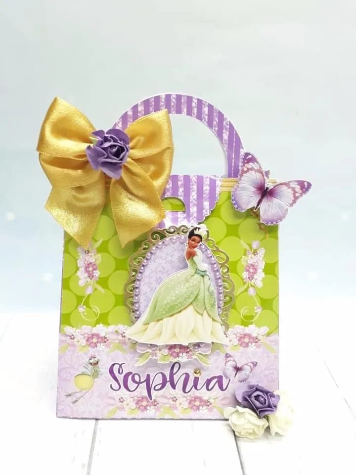 Arquivo de corte para caixa de papel simulando uma carruagem feita de folhas e ramos de vitória-régia, com rodas douradas e silhueta da Princesa Tiana.