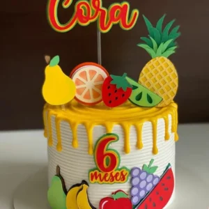 Topper de bolo infantil com o tema feirinha e frutas, exibindo apliques em camadas tridimensionais de melancia, morango, abacaxi e laranja sorridentes em estilo kawaii.