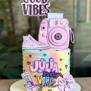 Topper de bolo com estilo Good Vibes exibindo elementos tropicais, flores delicadas, um sol poente e lettering moderno com mensagens positivas em camadas tridimensionais de papel.