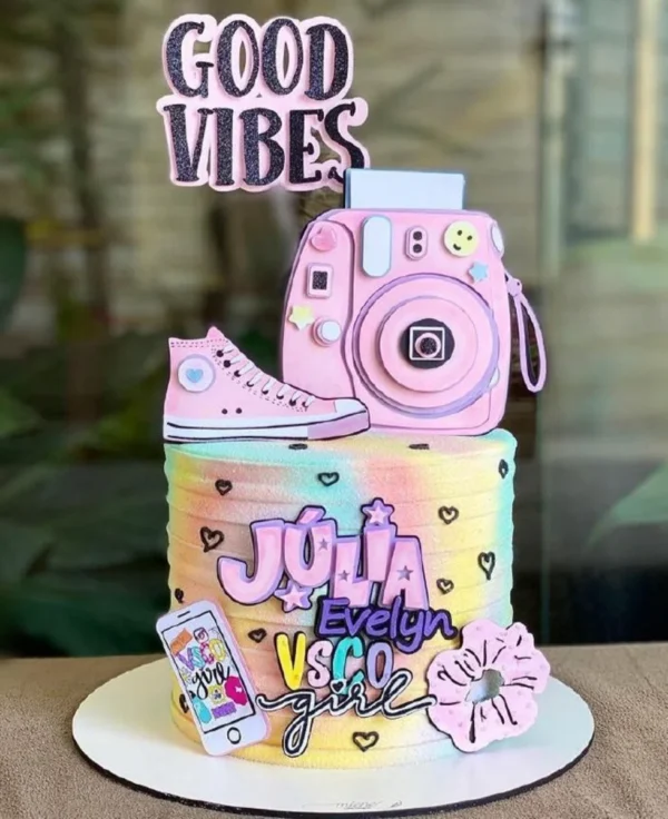 Topper de bolo com estilo Good Vibes exibindo elementos tropicais, flores delicadas, um sol poente e lettering moderno com mensagens positivas em camadas tridimensionais de papel.