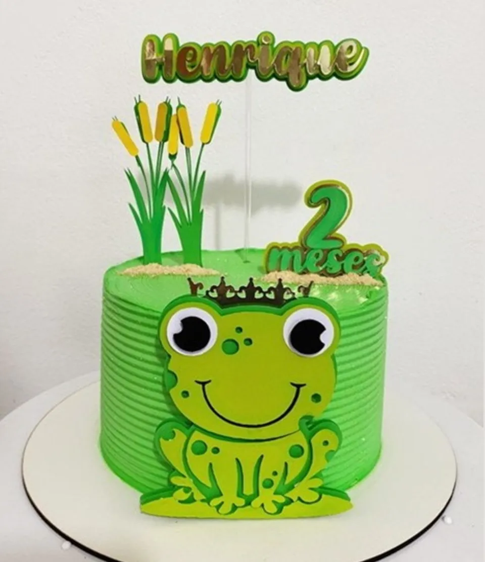 Topper de bolo com um sapinho verde fofo e sorridente sentado sobre uma vitória-régia redonda, cercado por pequenas flores aquáticas e taboas em camadas tridimensionais para decoração de festa em arquivo digital de corte.