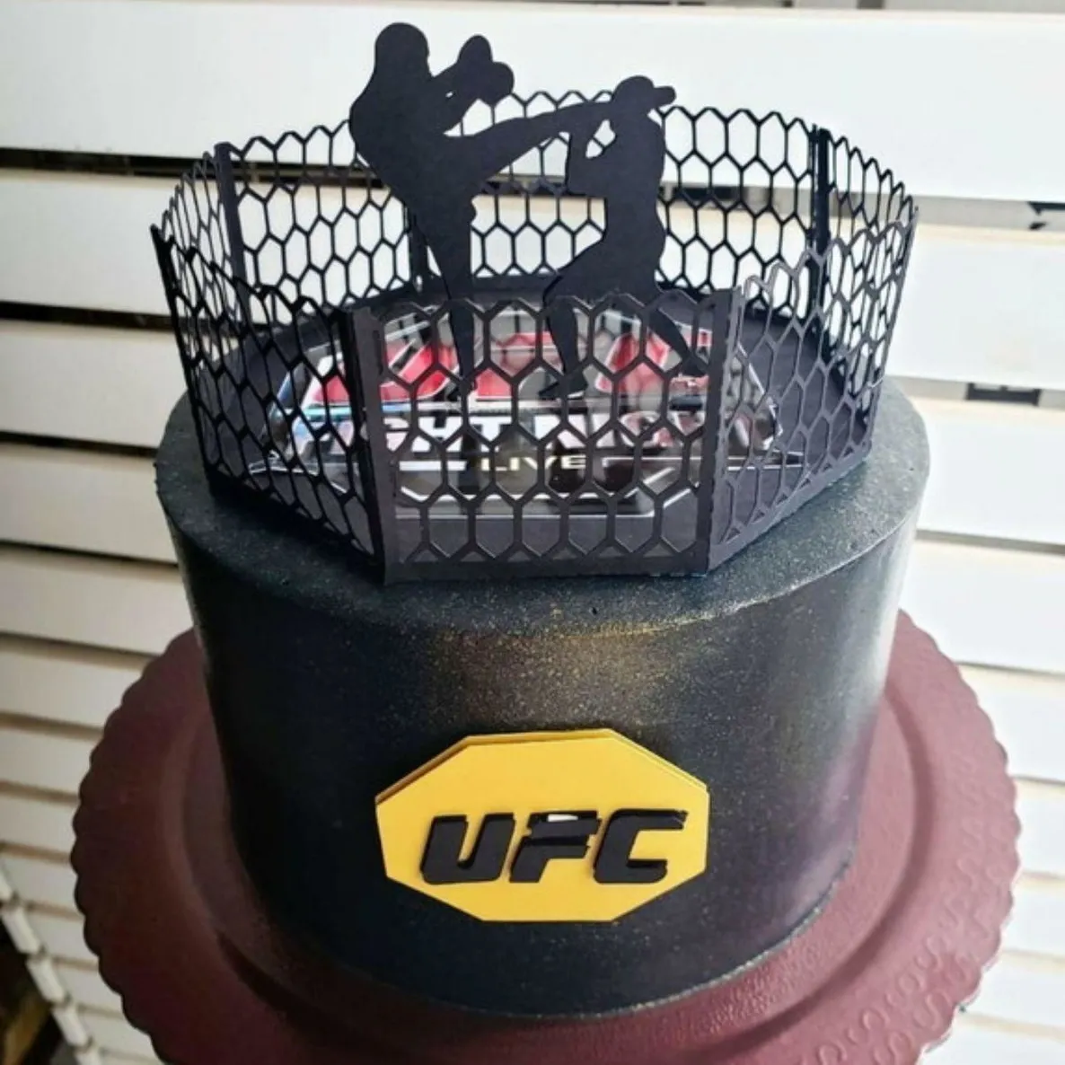 opper de bolo com o tradicional octógono preto com grades cinzas vazadas, trazendo o letreiro UFC em letras garrafais vermelhas com bordas pretas texturizadas, além de luvas de MMA pretas em camadas tridimensionais em arquivo digital de corte.
