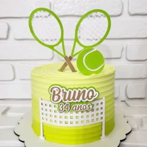 Topper de bolo esportivo com duas raquetes de tênis cruzadas ao fundo na cor prata, uma rede branca detalhada na base e uma bola de tênis amarela brilhante em destaque na frente em camadas tridimensionais em arquivo digital de corte.