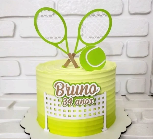 Topper de bolo esportivo com duas raquetes de tênis cruzadas ao fundo na cor prata, uma rede branca detalhada na base e uma bola de tênis amarela brilhante em destaque na frente em camadas tridimensionais em arquivo digital de corte.