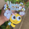 Topper de bolo infantil com uma colmeia amarela texturada em formato de gota ao centro, cercada por pequenas abelhinhas fofas com asas brancas e flores de margarida detalhadas com miolo amarelo dispostas em camadas tridimensionais em arquivo digital de corte.