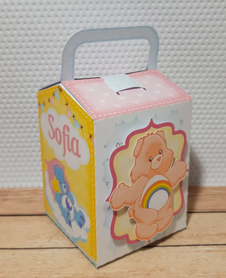 Quarto gabarito de caixinha personalizada com silhuetas dos Ursinhos Carinhosos com seus emblemas na barriga, mostrando a base de sustentação estruturada e marcas de corte limpas para produção.