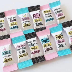 Gabarito digital para embalagem de balas personalizadas de agradecimento ao cliente com estampas delicadas, frases motivacionais e linhas tracejadas indicando o espaço para dobra e selagem do papel.
