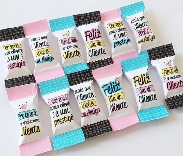 Gabarito digital para embalagem de balas personalizadas de agradecimento ao cliente com estampas delicadas, frases motivacionais e linhas tracejadas indicando o espaço para dobra e selagem do papel.