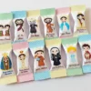 Rótulos para doces e balas decorados com a imagem de Santo Antônio segurando o Menino Jesus em fundo com arabescos suaves, contendo guias de corte em arquivo digital de corte.