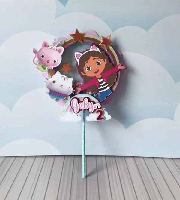 Embalagem cônica em formato de pirâmide decorada com patinhas e estrelas coloridas, trazendo no topo a personagem Gabby com seu arco de orelhas de gatinho em um aplique frontal em camadas tridimensionais, em arquivo digital de corte.