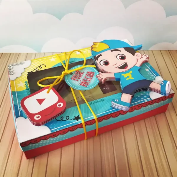 Molde de caixa maleta de papel com alça integrada, decorada com o Luccas Neto sorrindo e um visor vazado em formato de foca revelando os doces e confeitos.