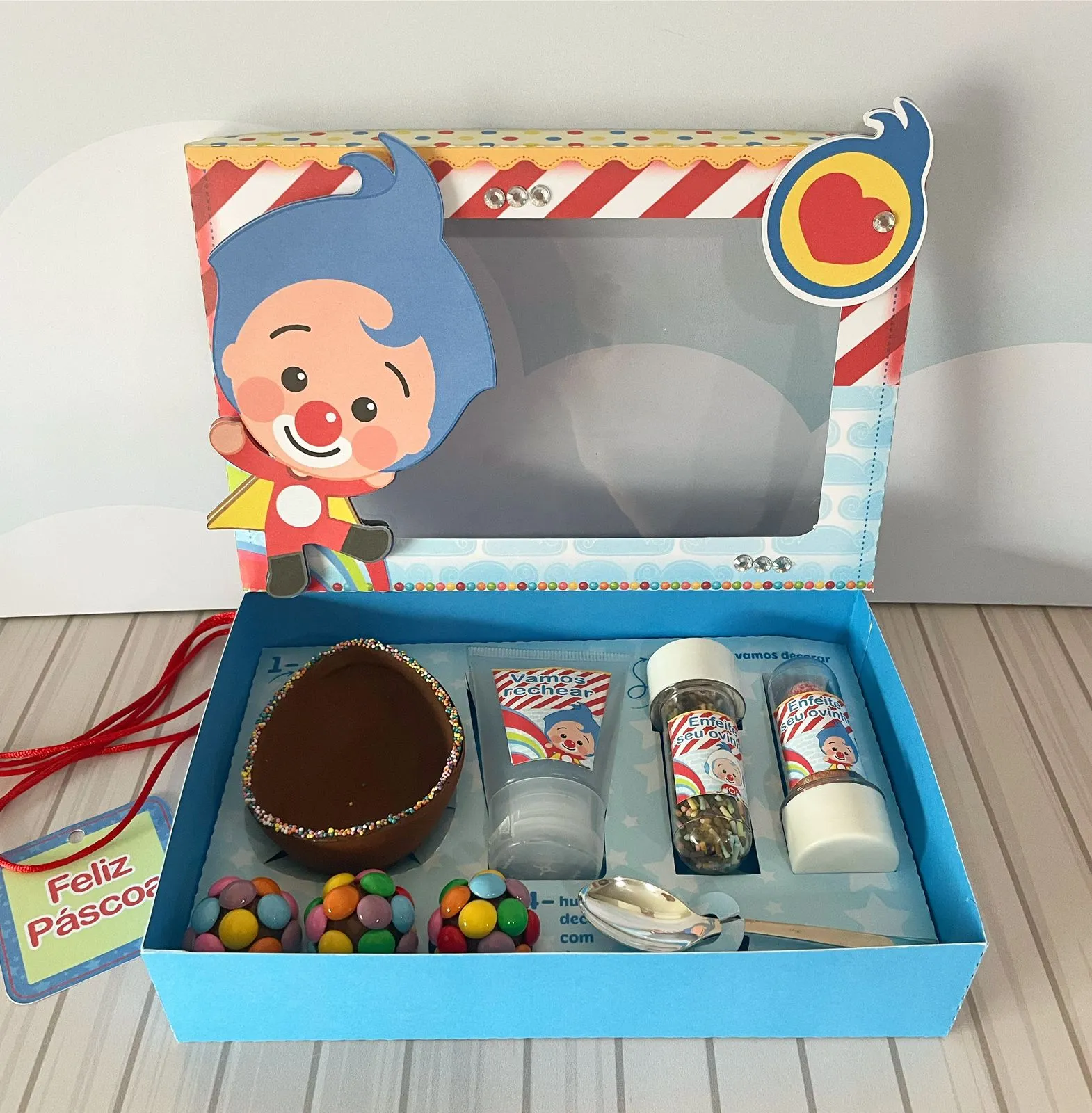 Caixa para kit confeiteiro com tampa impressa exibindo o Plim Plim ao lado do urso Bam e da gata Mei, moldura colorida de estrelas e berço interno para bisnaga de doce em arquivo digital de corte.