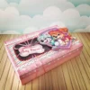 Arquivo de corte de caixa dupla face com tampa de papel, contendo uma divisória para os doces e confeitos na base e um livreto de colorir preso no interior da tampa.