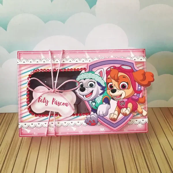 Molde de caixa maleta de papel com alça integrada, decorada com a Skye e a Everest voando nas montanhas e visor em formato de patinha revelando os confeitos.