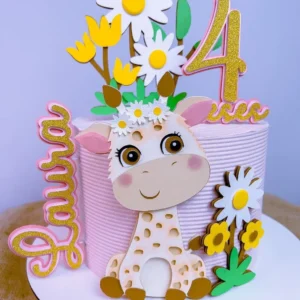 Topper de bolo infantil com uma girafinha filhote sorridente usando uma coroa de flores na cabeça, cercada por grandes flores de papel abertas em tons pastéis e ramos de folhas delicadas dispostos em camadas tridimensionais em arquivo digital de corte.